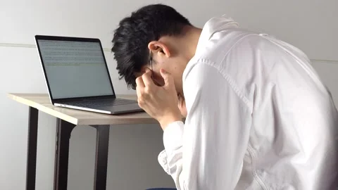 Man looking sad and having a headache in front of desk Stock Footage 130709146
