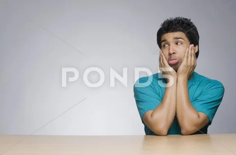 Man looking sad with his head in his hands Stock Photos