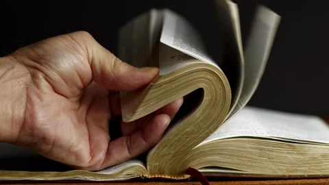 A man looking for a scripture in the Bible Видео 335774483