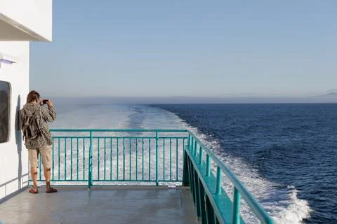 Man looking at the sea from the deck of a ferry Stock Photos