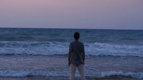 Man looking on sea waves at sunset Stock Footage 104822053