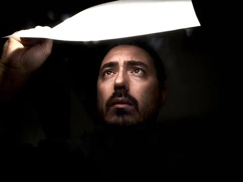 Man Looking at Semi-Transparent Object Towards the Light Foto stock
