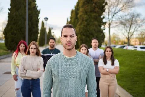 Man looking serious at the camera while standing in front of a group of people. Foto stock