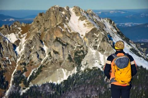 Man looking to sharp rocky mountains during calm winter colorful sunset Stock Photos