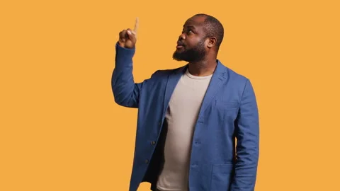 Man looking up, showing something to audience, studio background Stock Footage 272365127
