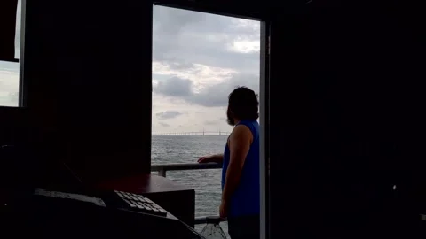 Man looking at Skyway bridge seen through doorway on cloudy morning 動画素材 158842165