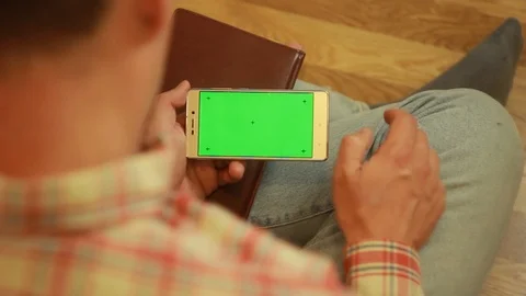 Man looking into the smartphone and sitting on the floor Stock Footage 91662740