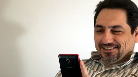 Man looking at smartphone and smiling Stock Footage 93098796