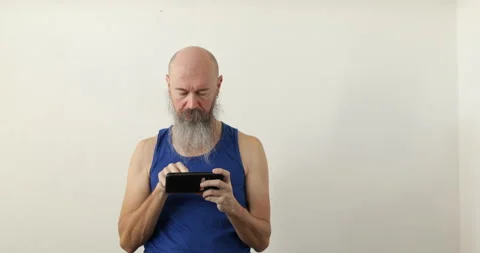 Man looking into smartphone prior physical exercise Stock Footage 236721080