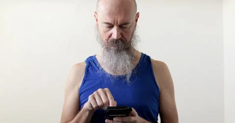 Man looking into smartphone prior physical exercise Stock Footage 236780956
