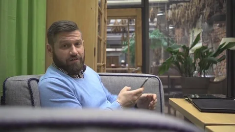 Man looking, smiling, laughing at camera in pub, cafe, indoor, steadycam Vidéo 73076066