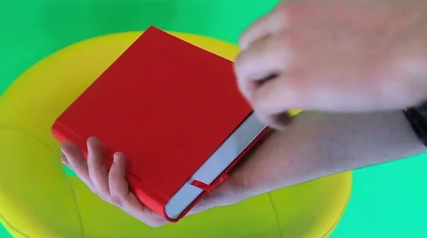 Man looking for something in the book with a green background Stock Footage 60745353