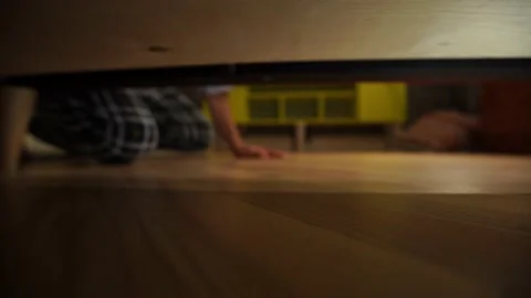Man Looking For Something Under The Bed. The hand gropes for an object Stock Footage 169368145