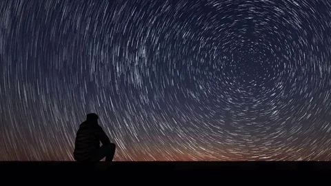 Man looking at the stars. Alone man looking at starry sky. Night sky. Star Trail Stock Footage