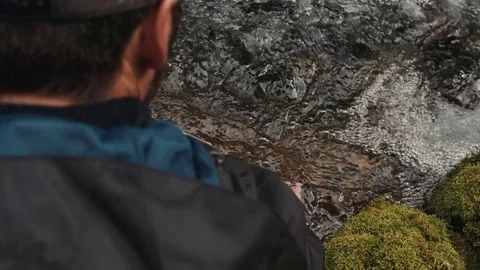 Man Looking At Stream And Puts Hand In Water Stock Footage 83598589