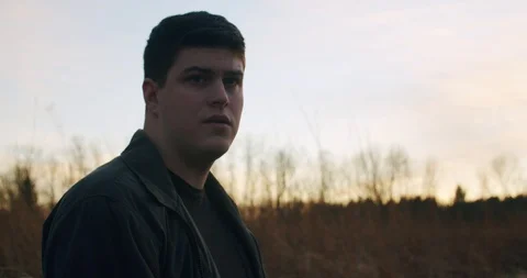 Man Looking into Sunset Turns to Look Hopeful just off camera Stock Footage 122221490