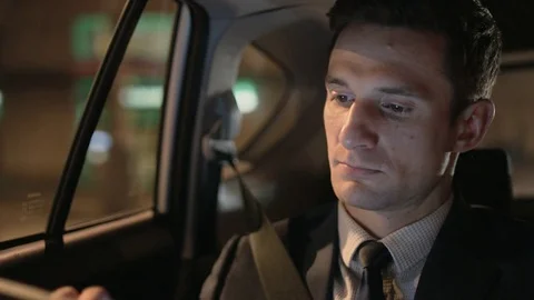 Man Looking at a Tablet and Through the Window in the Car Stock Footage 75744926