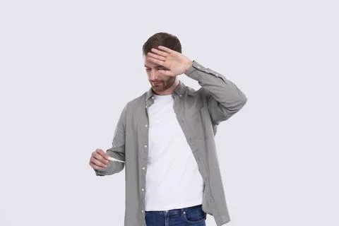 Man Looking at Thermometer Feeling Sick. Checking Themperature. Isolated Stock Photos