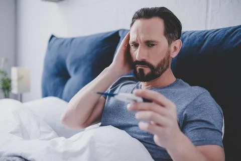Man looking at thermometer Stock Photos
