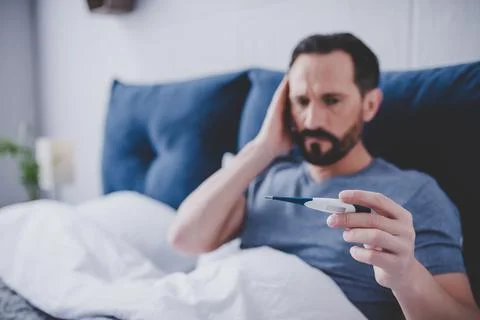 Man looking at thermometer Stock Photos