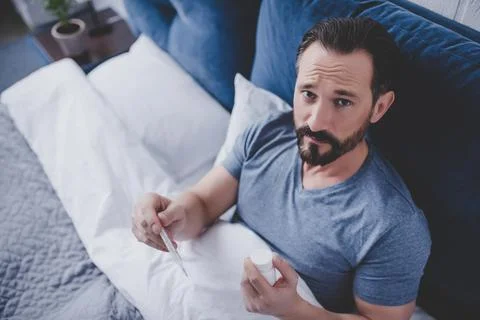 Man looking at thermometer Stock Photos