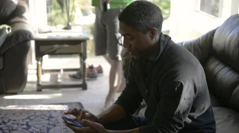 Man looking things up on his smart phone, and talking to people passing by Stock Footage 62722372