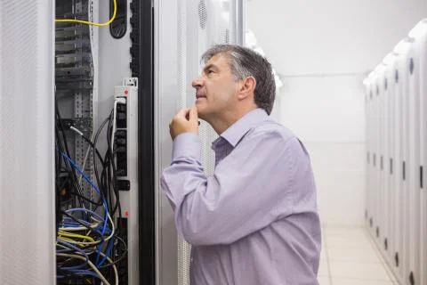 Man looking up thoughtfully into server locker Stock Photos