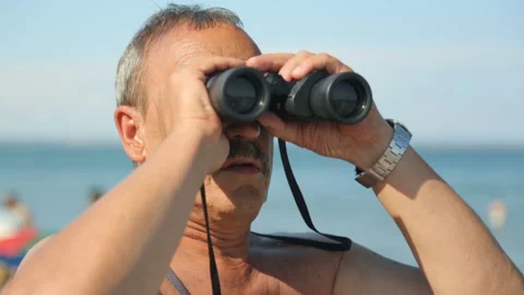 Man is looking through binoculars on beach Stock Footage 96462665