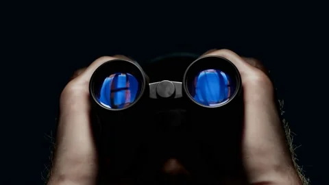 A man looking through binoculars. A guy with field glasses watching a target. Stock Footage 145768710