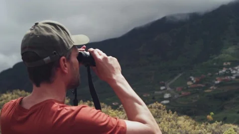 Man looking through binoculars on the mountain Stock Footage 81543038