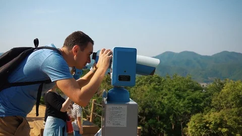 Man Looking through binoculars overlooking the city of Kyoto in Slow Motion Stock Footage 111909412