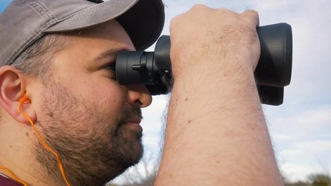 Man Looking Through Binoculars in Slow Motion Stock Footage 124981862