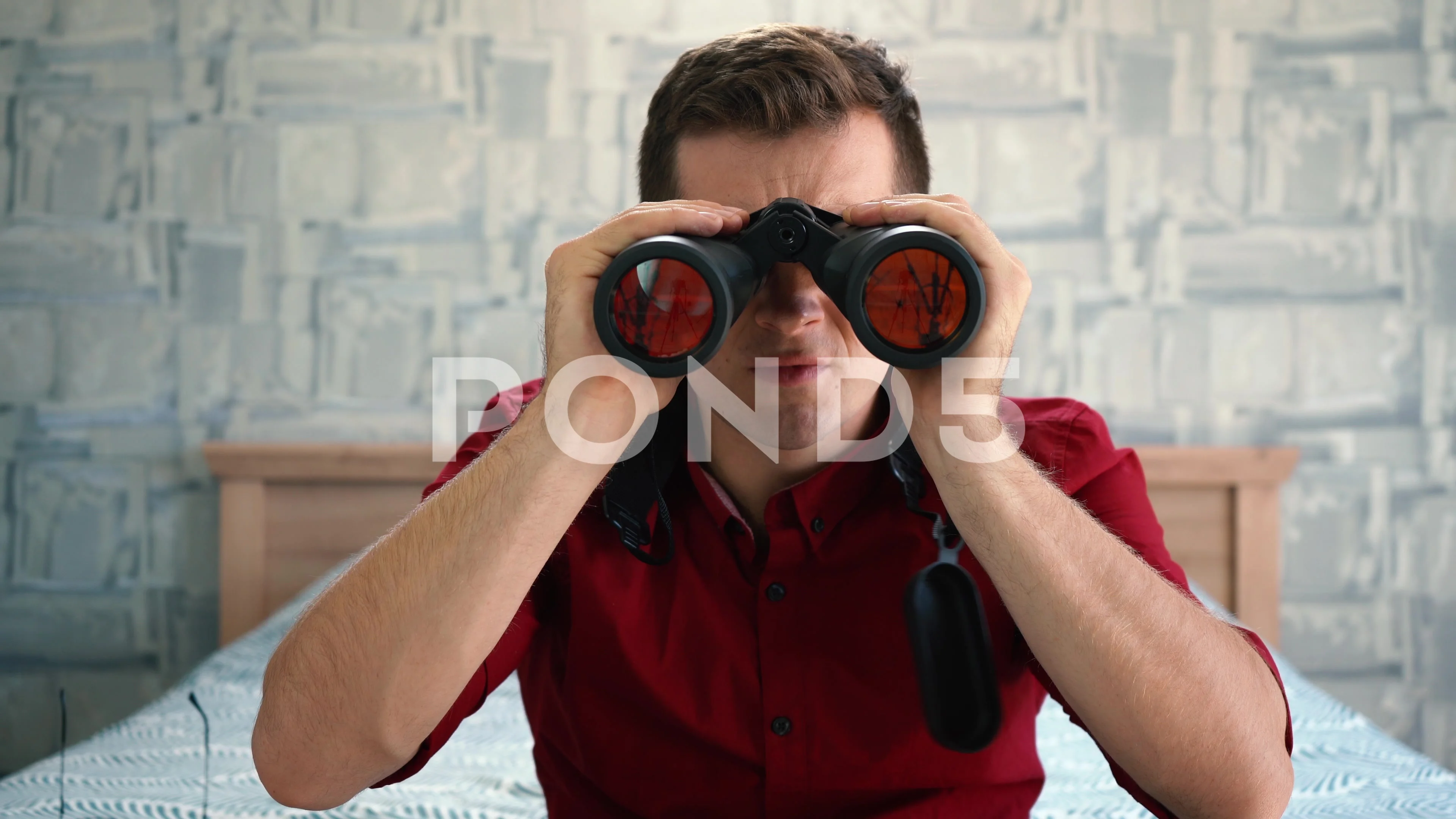 man looking through binoculars is surprised