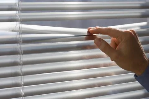 Man looking through blinds Stock Photos