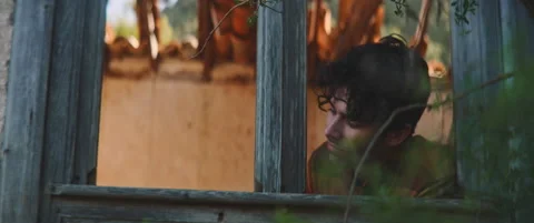 Man looking through glasless window frame Stock Footage 202266475