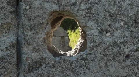 Man looking through a hole in a concrete wall Stock Footage 59525408