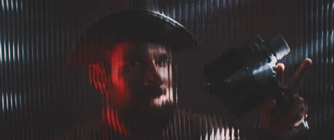 Man looking through line shaped clear panel in red light Stock Footage 203571437