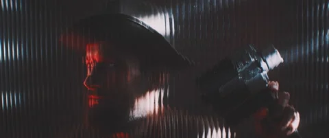 Man looking through line shaped clear panel in red light Video stock 203571676