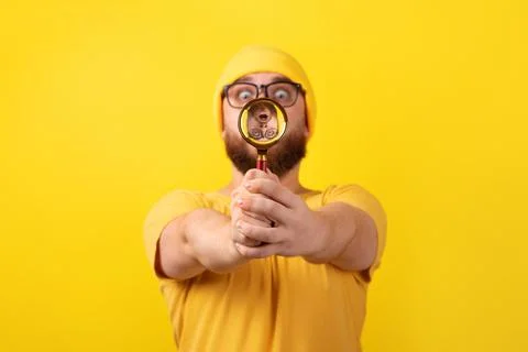 Man looking through magnifier Stock Photos
