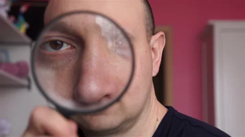 Man looking through a magnifying glass Vidéo 60036560