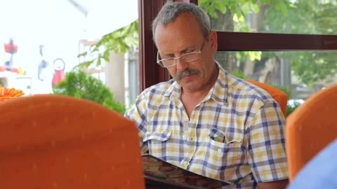 Man is looking through menu in cafe Stock Footage 96354881