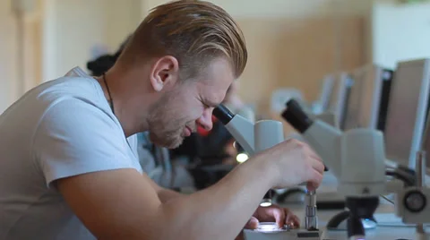 Man looking through a microscope Stock Footage 32254173