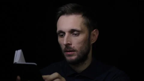 A man is looking through a notebook, 스톡 동영상 145685699