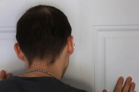Man looking through peephole from inside checking visitor concept Stockfoto's