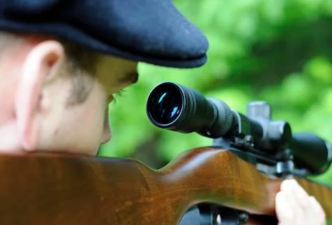 Man looking through scope on a rifle gun Stock Photos