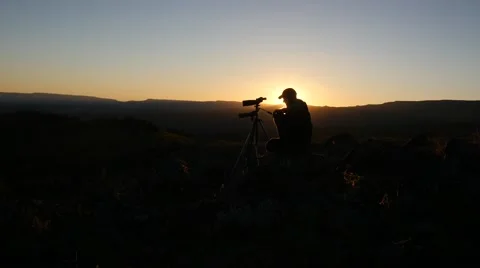 Man looking through spotting scope at sunset. Stock Footage 42482062