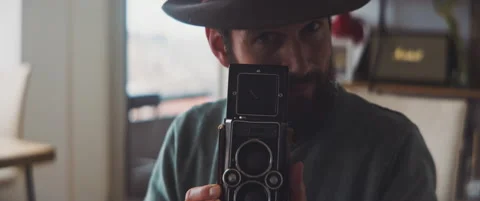 Man looking through a visor of a medium format camera and taking a photo Stock Footage 202248997
