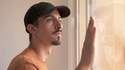 Man looking through the window and grabbing his mask off. Coronavirus. Vidéo 131250326