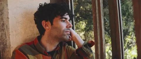 Man looking through window frame on a windy day Stock Footage 202267299