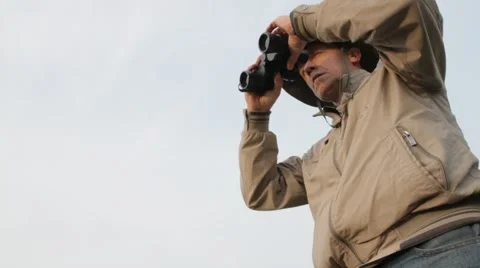 Man looking upward with an old pair of binoculars Stock Footage 61283688